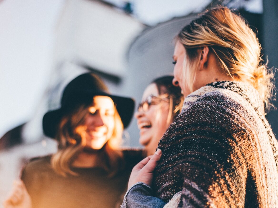 people laughing and talking outside during daytime