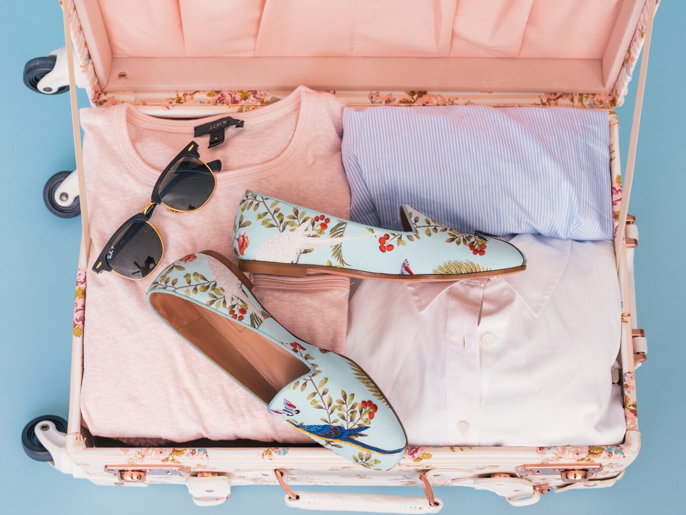 clothing items and pair of shoes in luggage