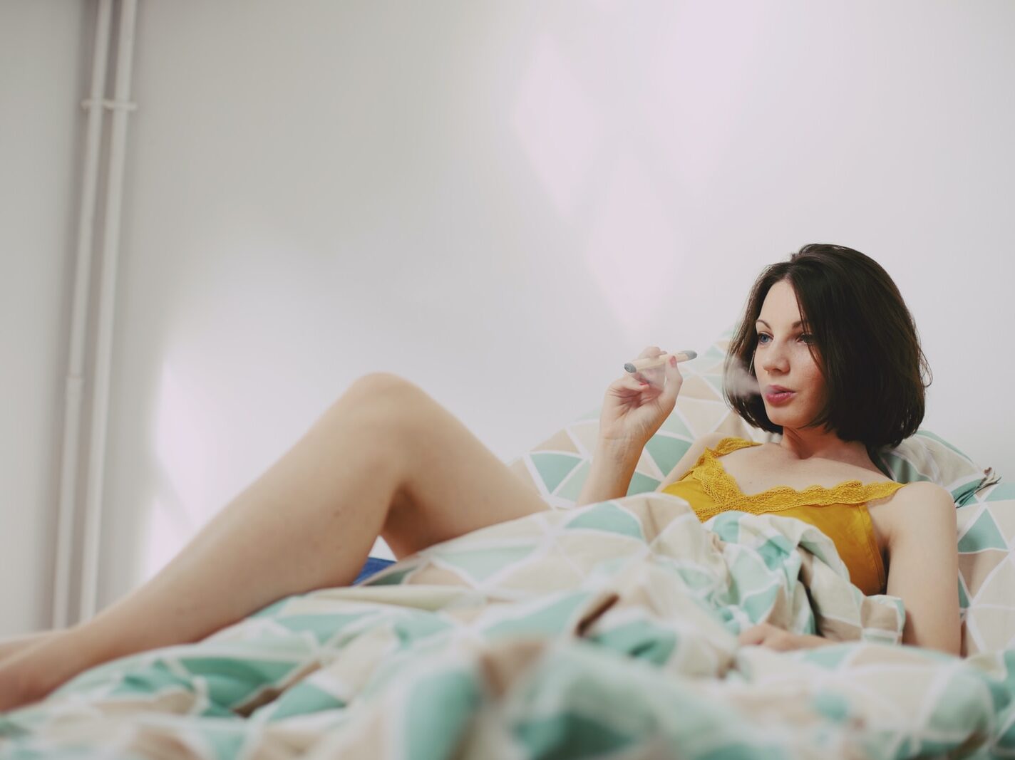 woman in yellow shirt lying on bed