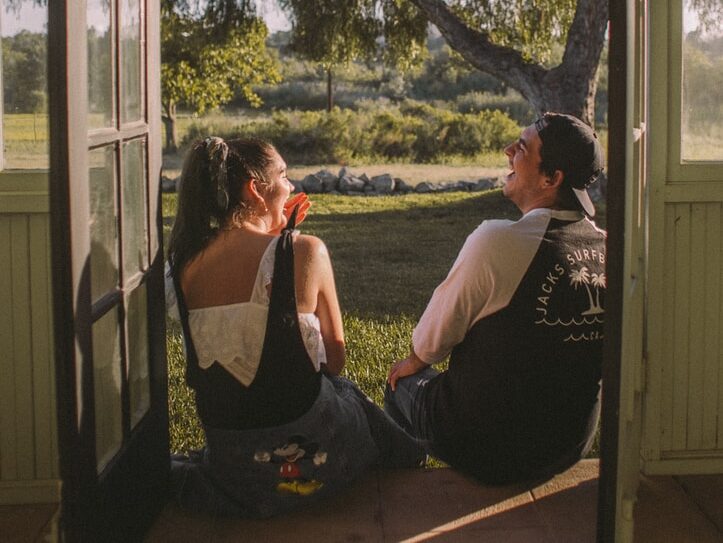 woman and man sitting near opened door