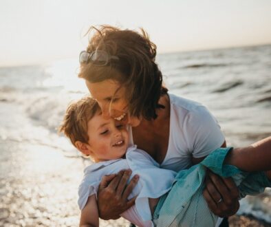 photo of mother and child beside body of water