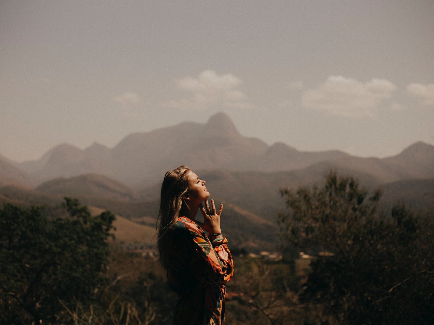 woman in black jacket standing on green grass field during daytime