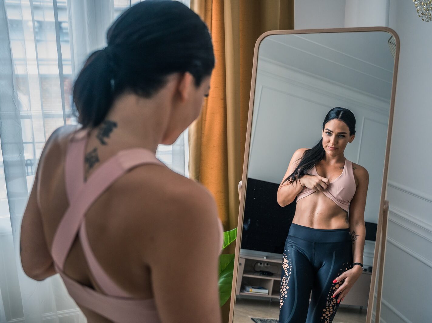 woman in black tube top and blue denim jeans standing beside man in black suit