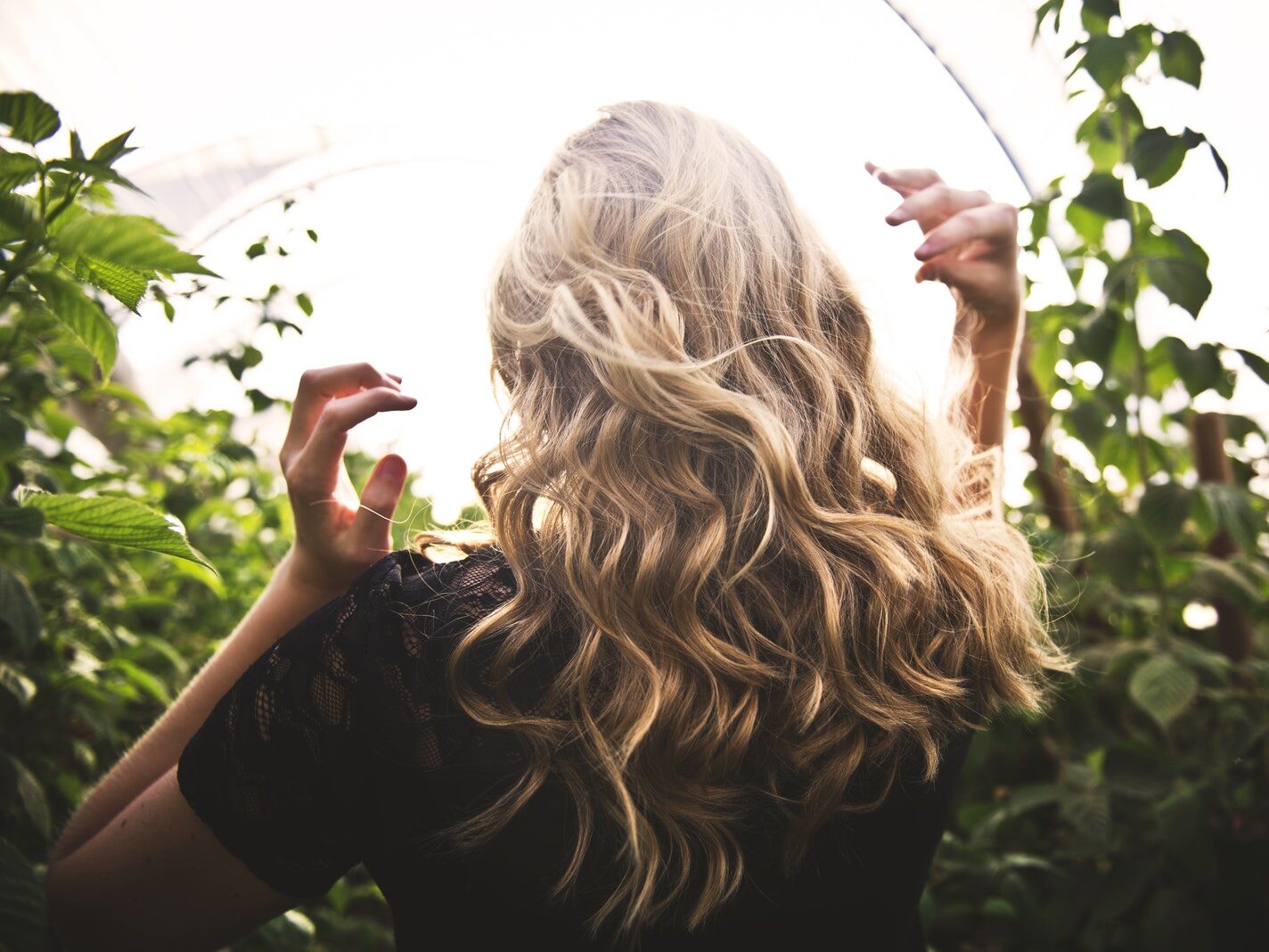 Blonde-haired Woman Standing Between Green Plants