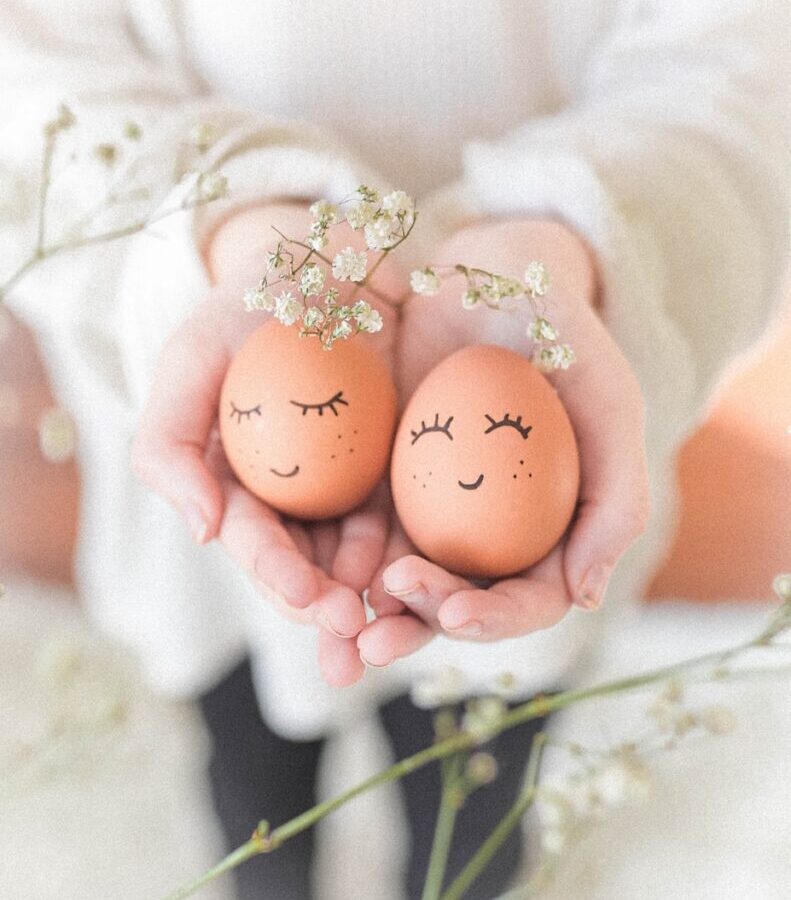 woman in white wedding dress holding two brown eggs
