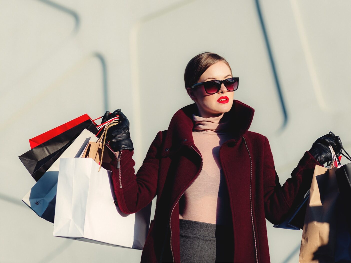 photo of woman holding white and black paper bags
