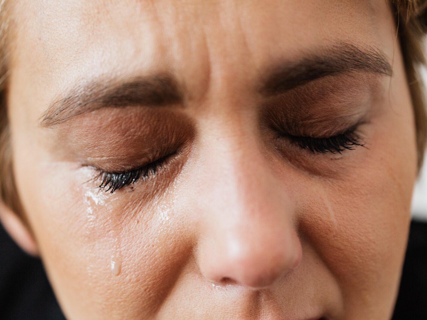 Tears on face of crop anonymous woman