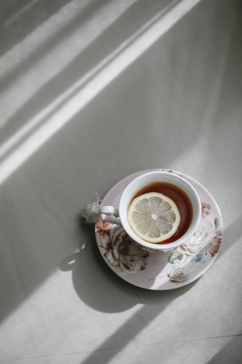 Charlotte May - ČasProŽeny.cz Top view of hot aromatic tea with slice of lemon on plate placed on table
