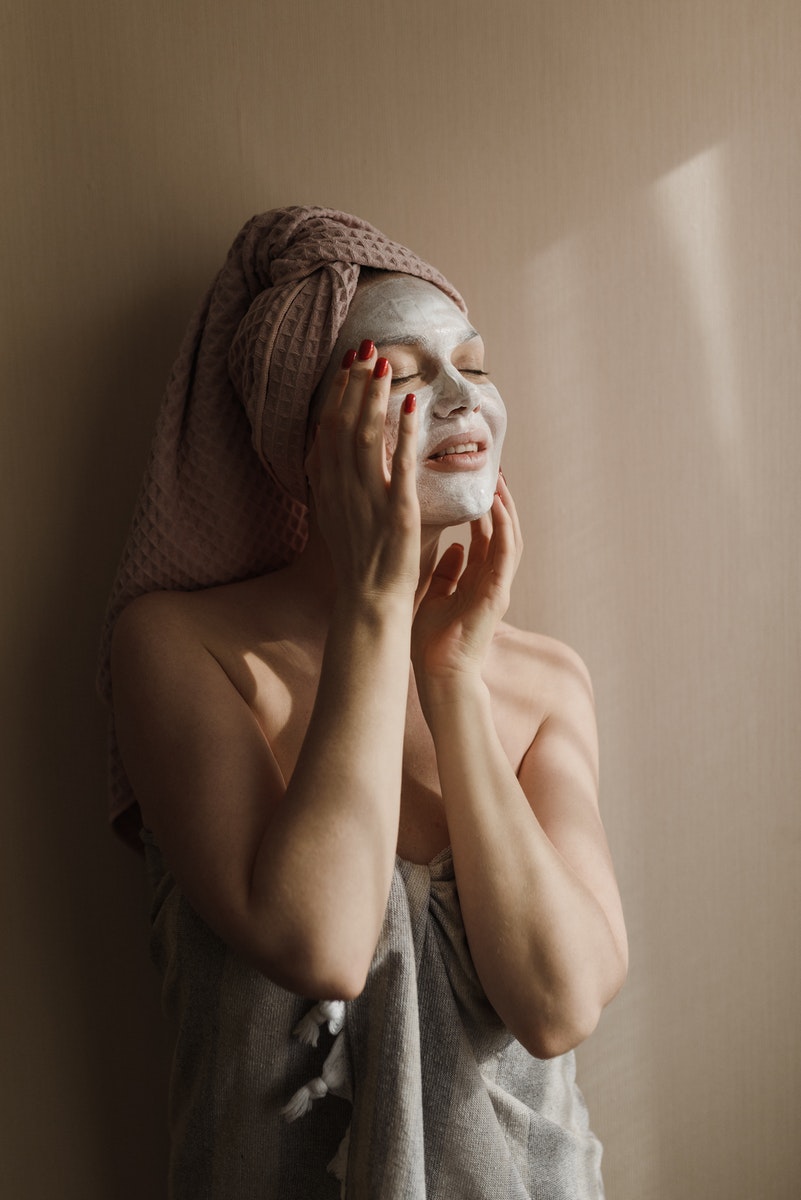 A Woman Wearing a Towel and a Facial Care Product