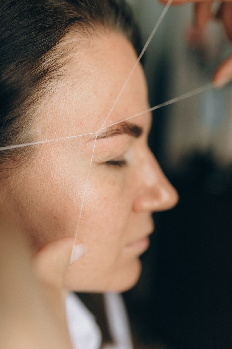 A Side View of a Woman Having a Threading Procedure