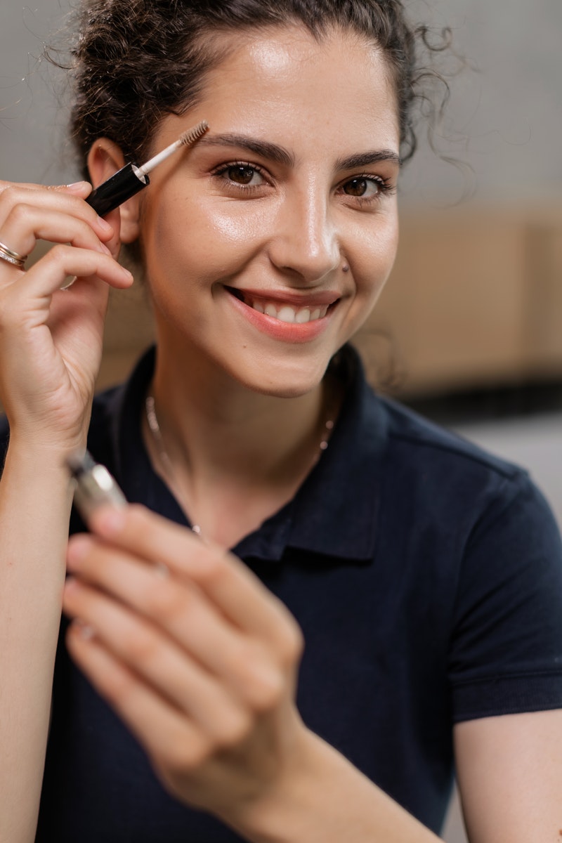 A Woman Applying an Eye Brow Makeup