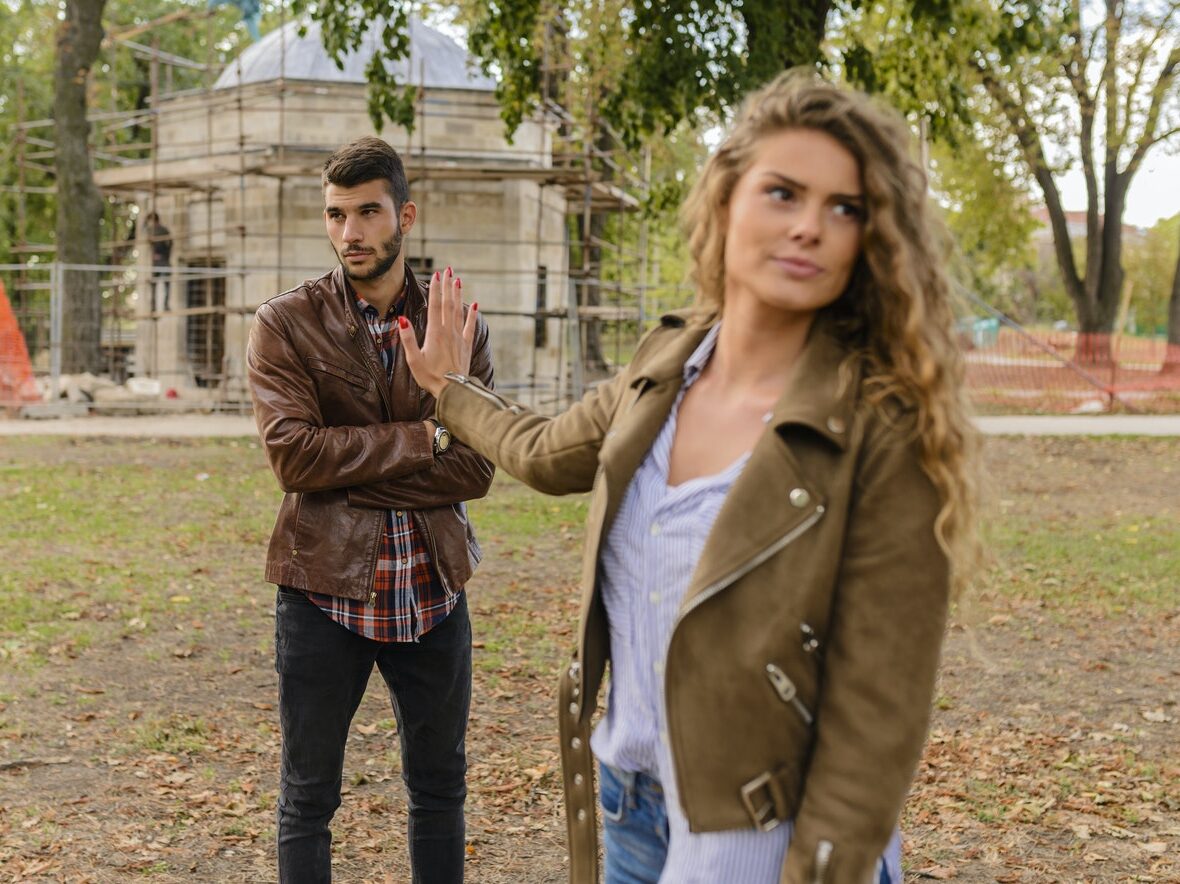 Man and Woman in Brown Leather Coat Standing on Brown Soil