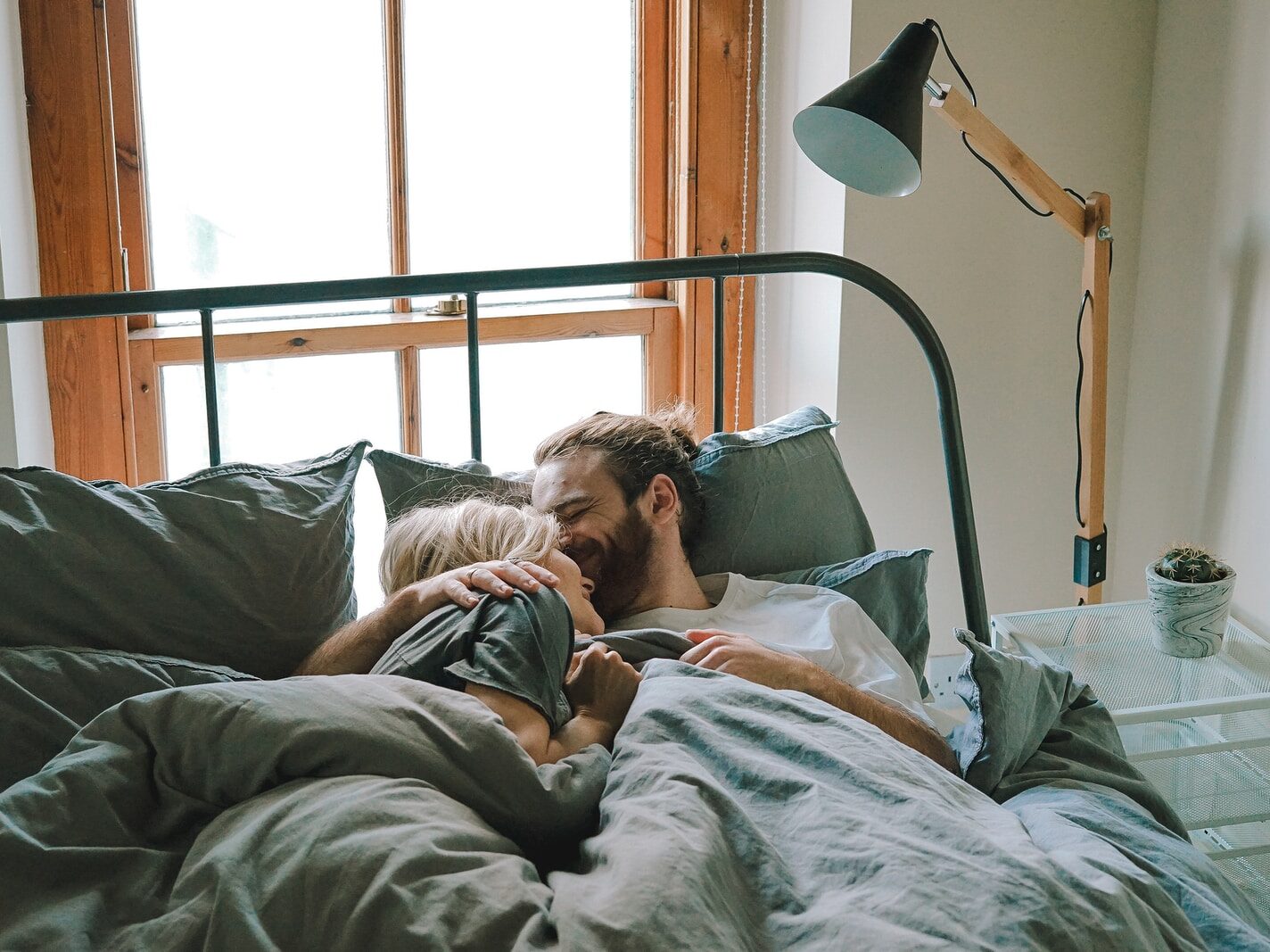man kissing woman on her forehead