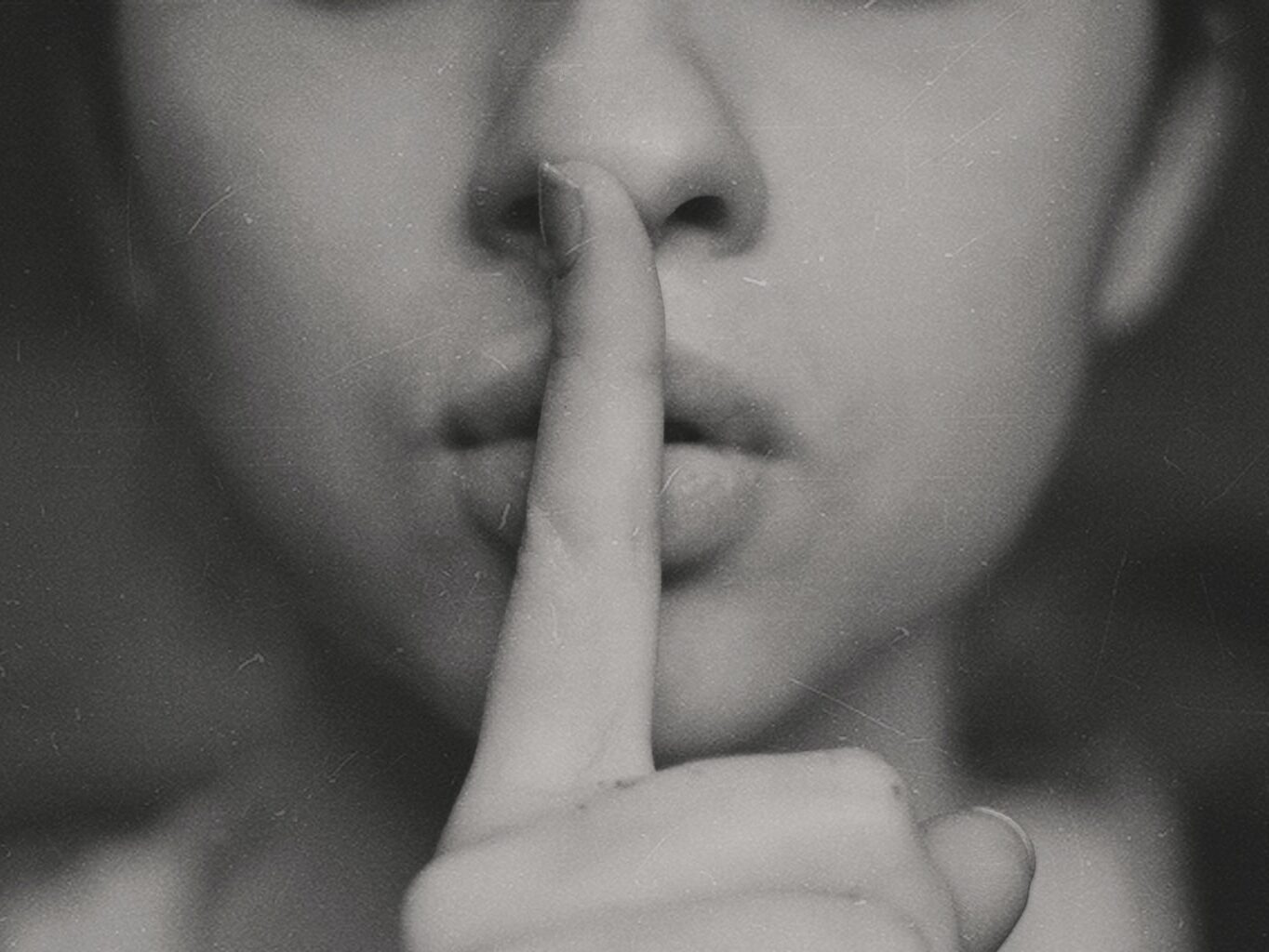 grayscale photo of woman doing silent hand sign