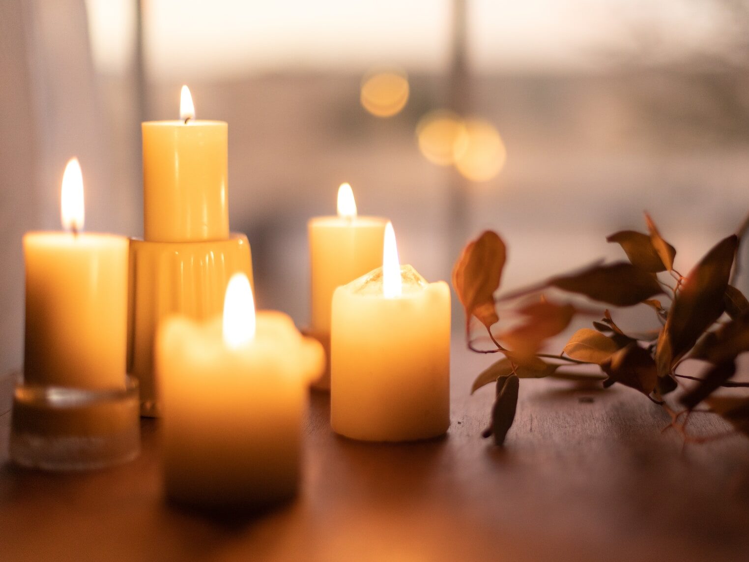white pillar candles on brown wooden table