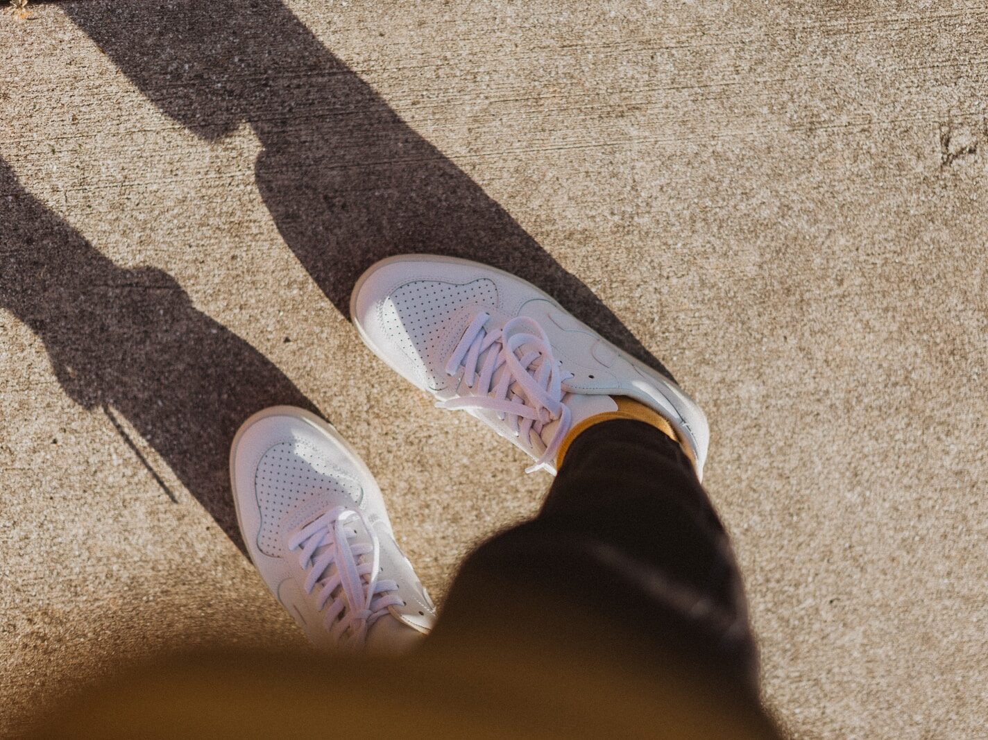 person wearing white nike athletic shoes