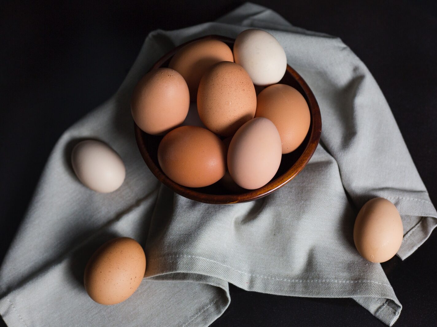 beige and white eggs on brown wooden bowl