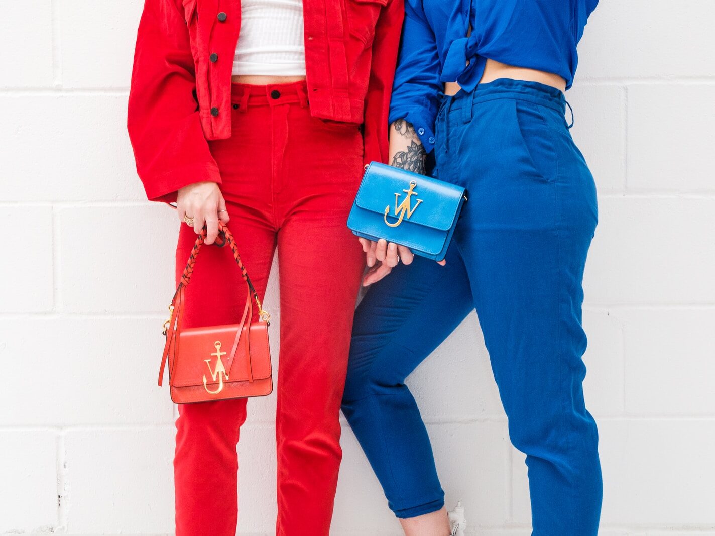person in blue denim jeans holding blue and white plastic cup