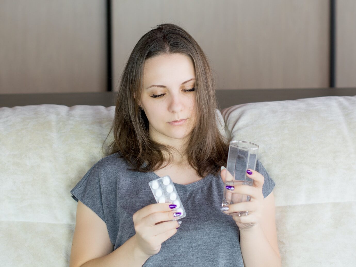 woman in gray crew neck t-shirt holding iphone
