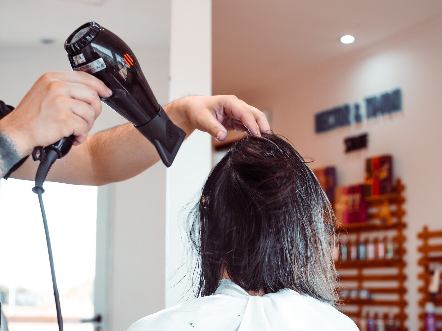 woman in white shirt holding hair blower