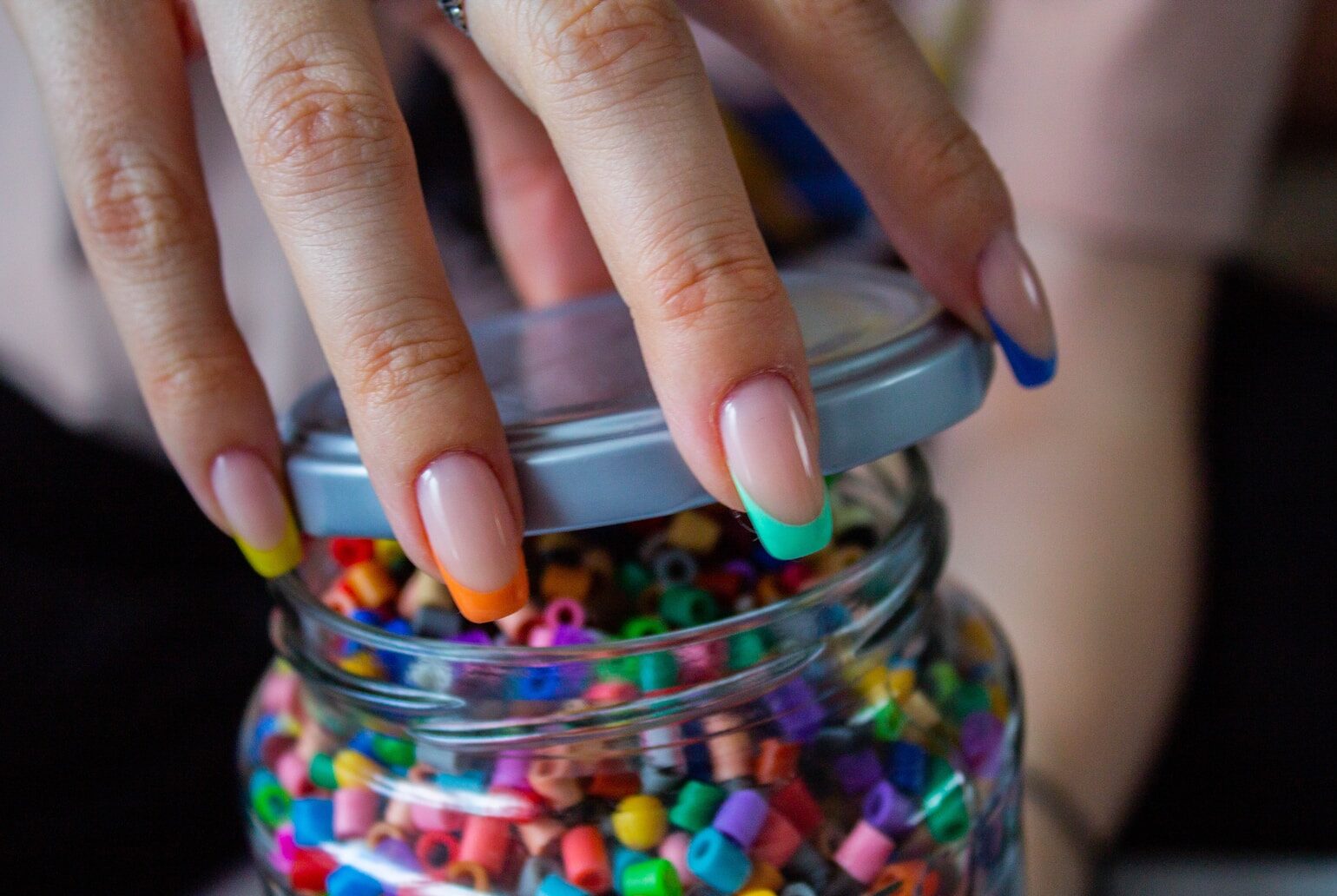 person holding clear glass jar with candies