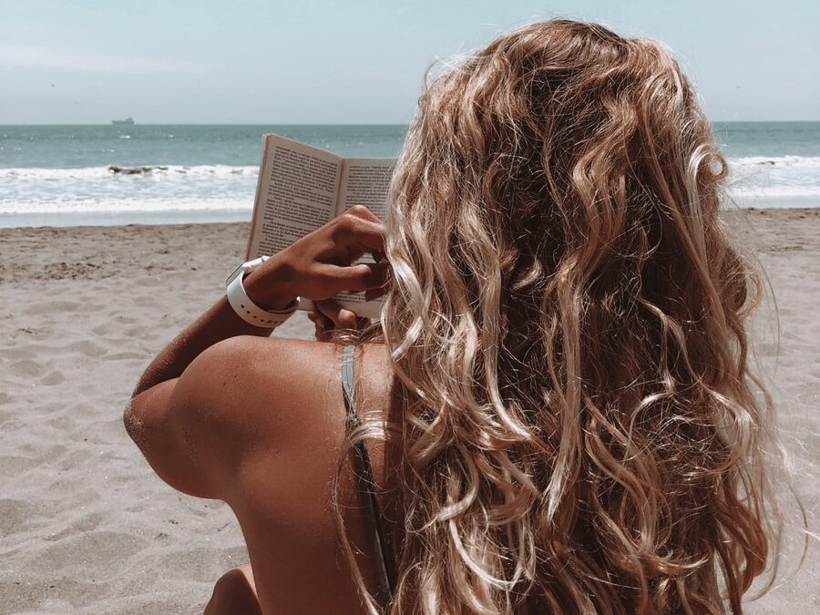 woman in brown bikini holding book