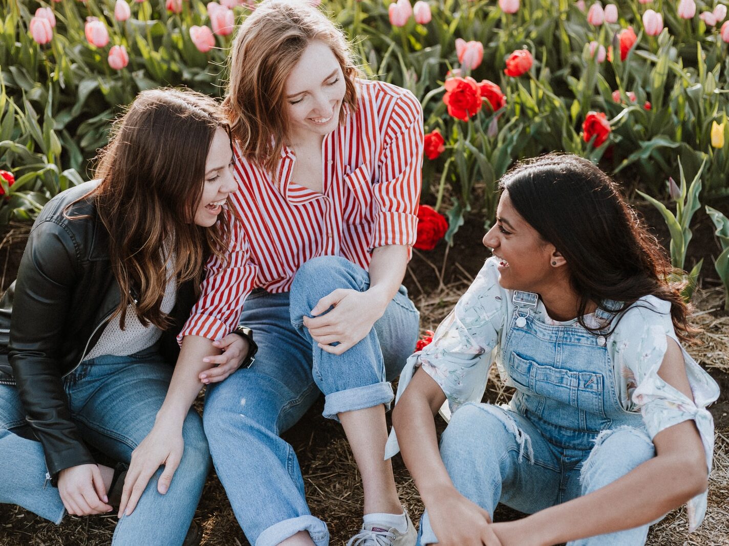 three woman sitting near the flower