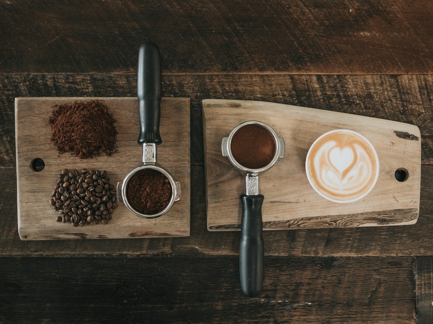 coffee beans beside coffee powder on brown wooden board