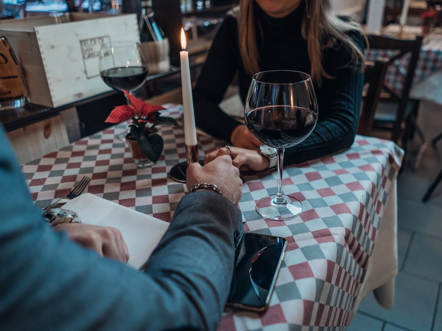 woman wearing black sweater holding hand with man wearing gray suit jacket