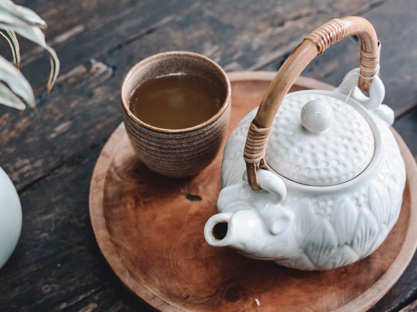 white and brown ceramic teapot on wooden tray