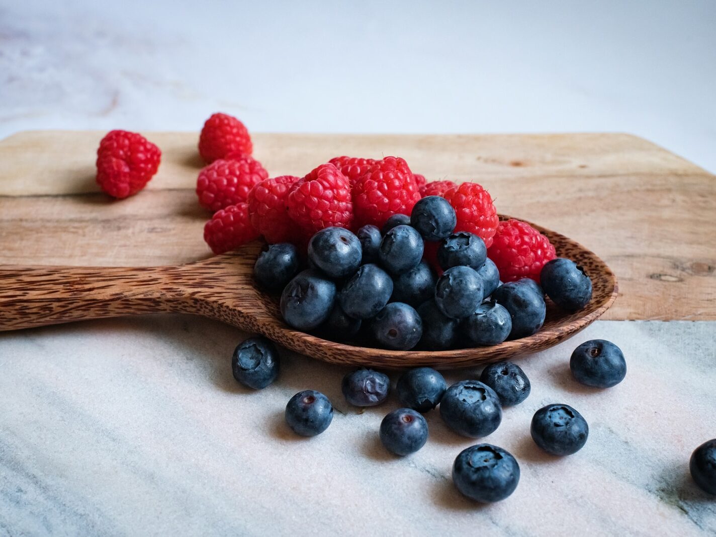 black berries on brown wooden spoon
