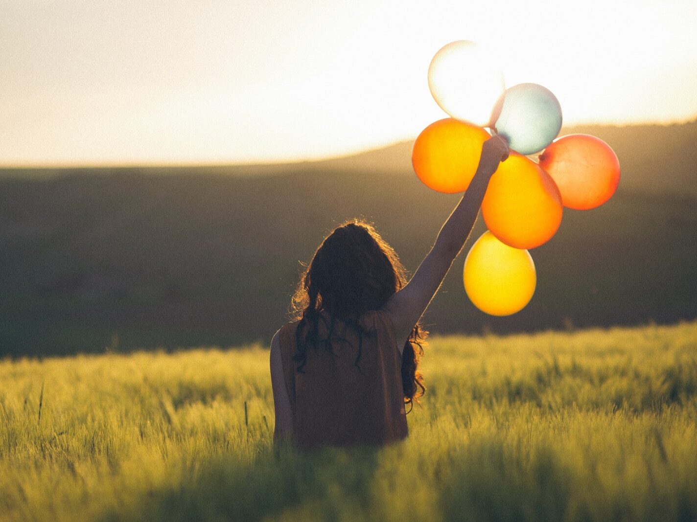 unknown person holding balloons outdoors