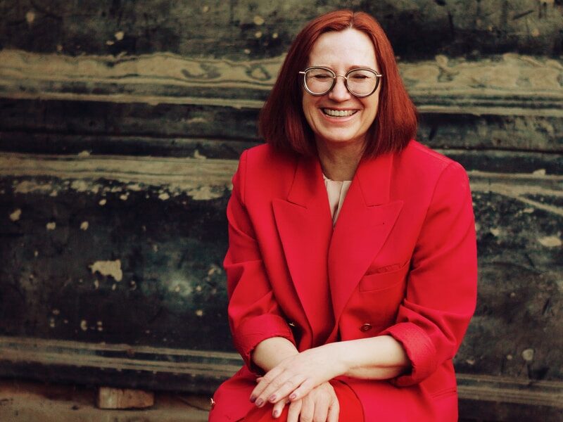 - ČasProŽeny.cz woman in red blazer and black skirt sitting on brown concrete stairs