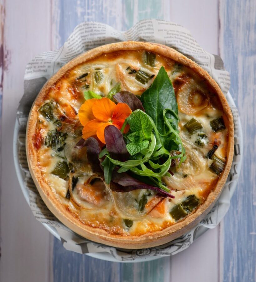 pizza with green leaf vegetable on white ceramic plate