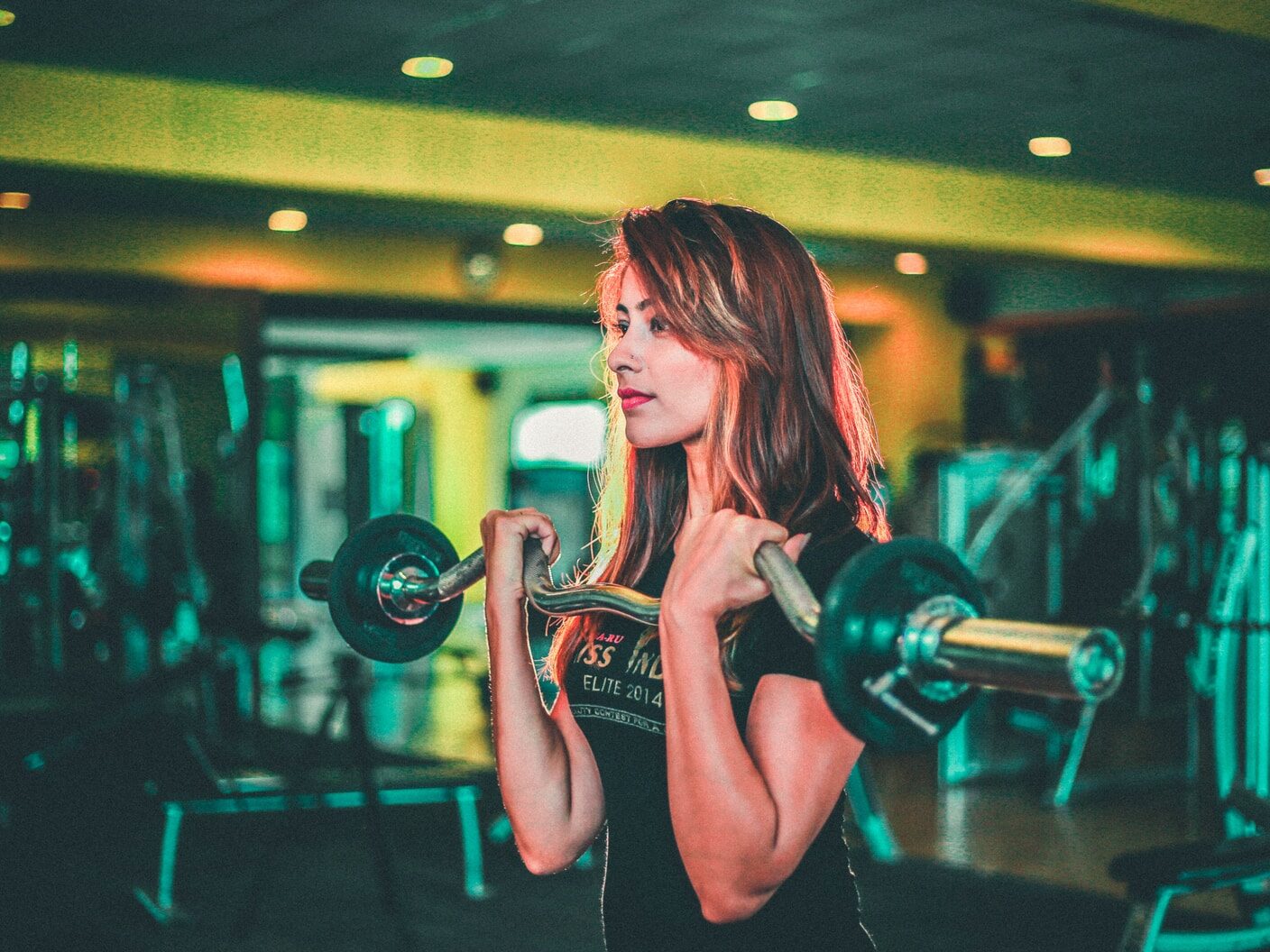 woman lifting black and gray barbell