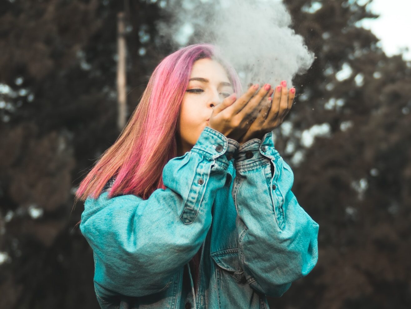 woman blowing powder off her hands