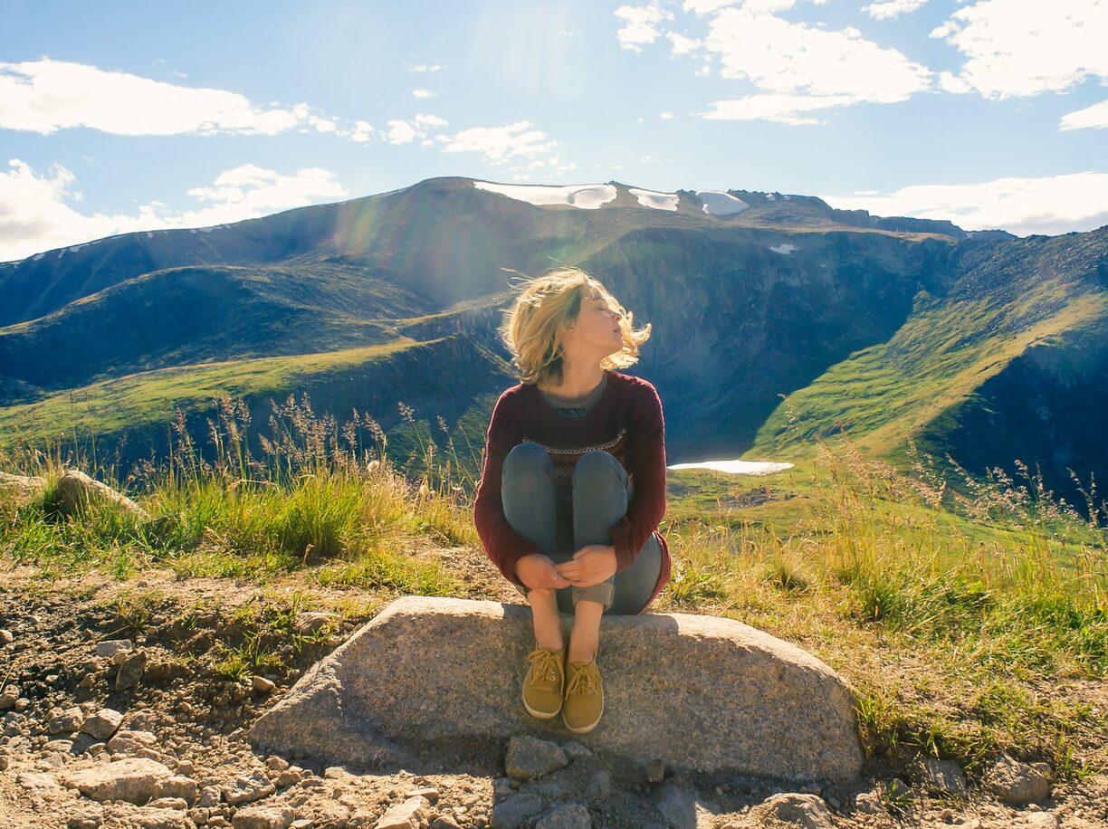 woman sitting on rock