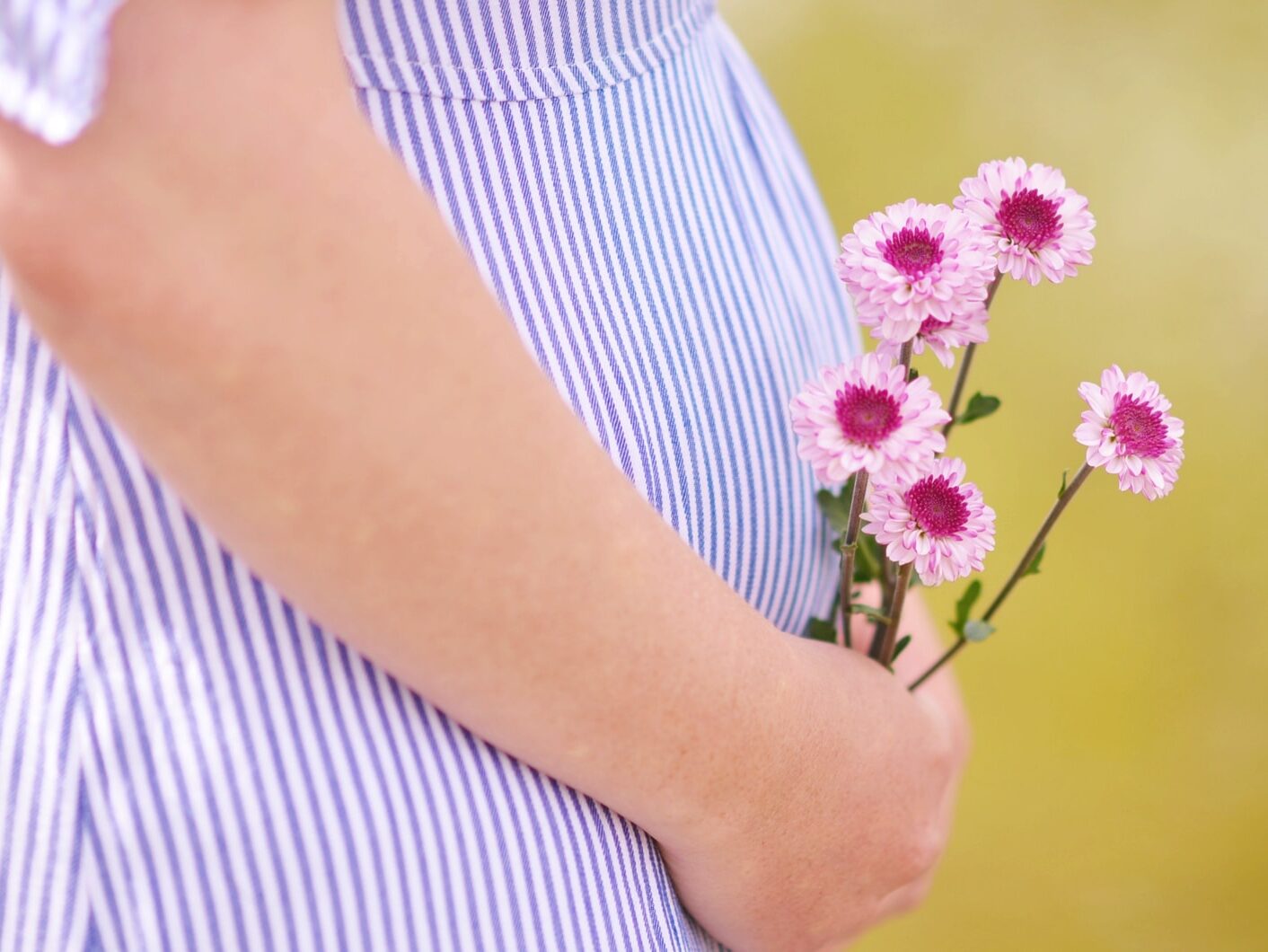 pregnant woman holding petaled flowers