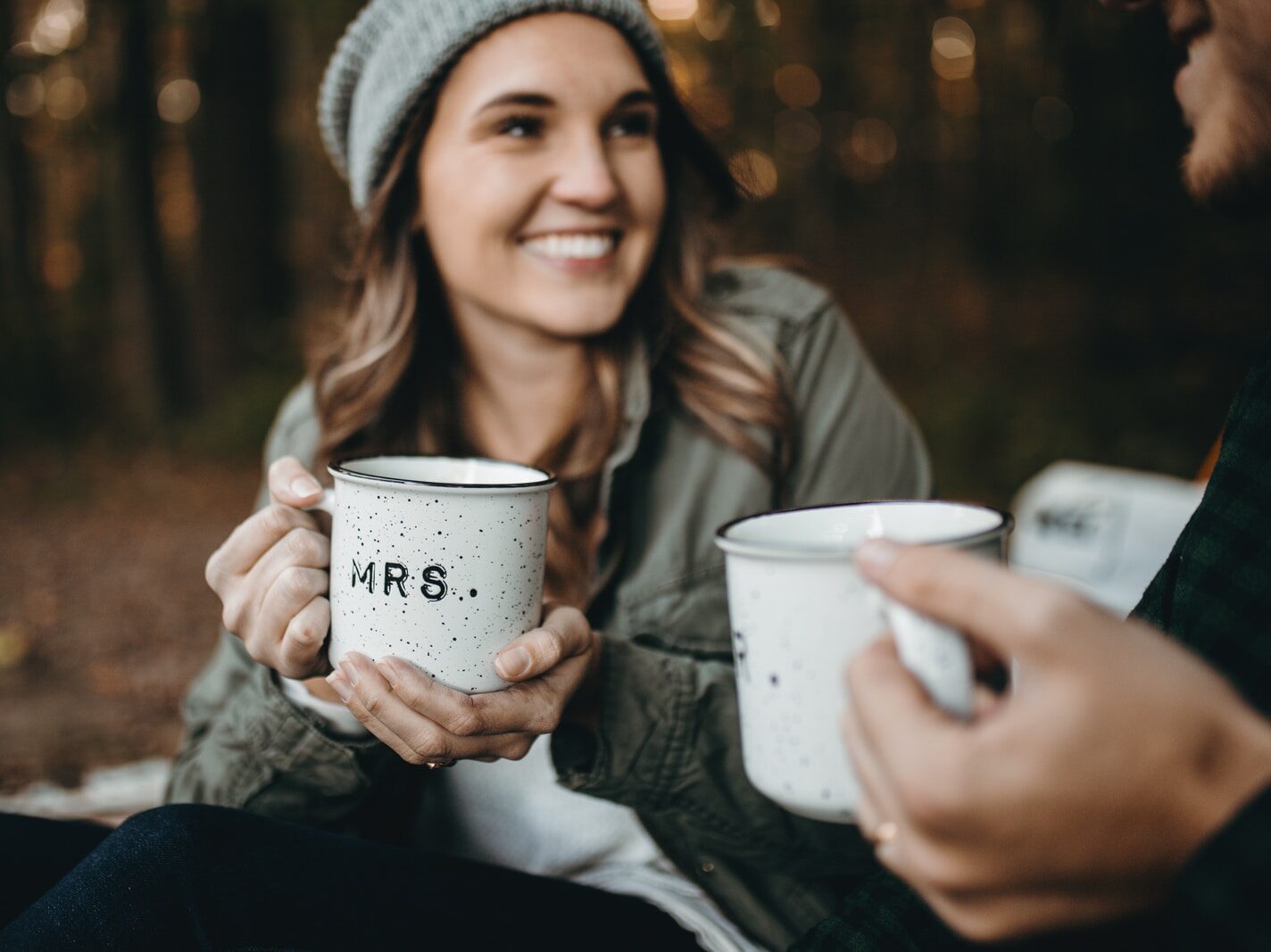 woman holding white mugs