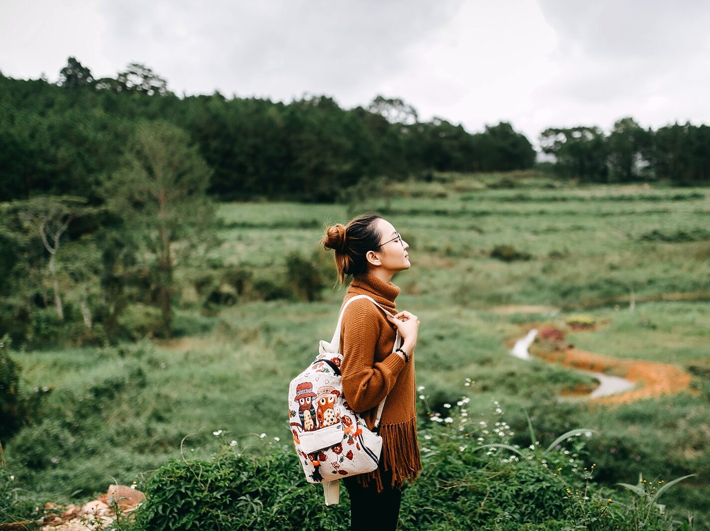 woman standing in the middle of grass field