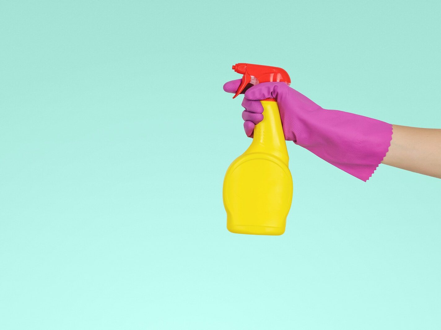 person holding yellow plastic spray bottle