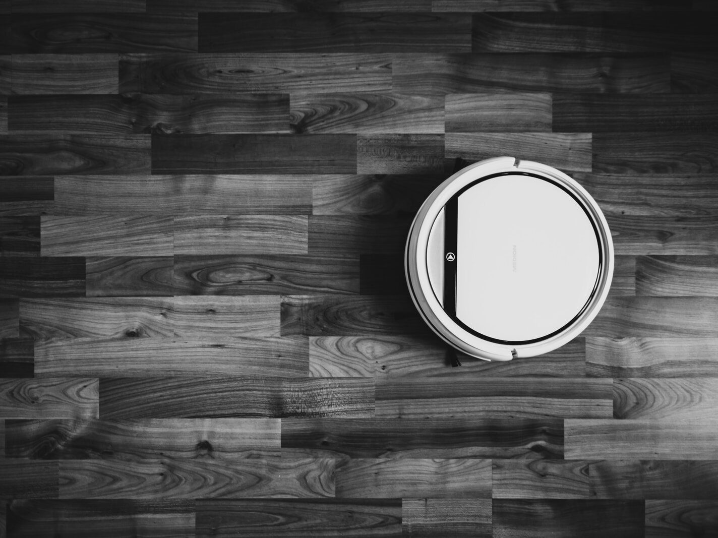 grayscale photo of round frame on wooden floor