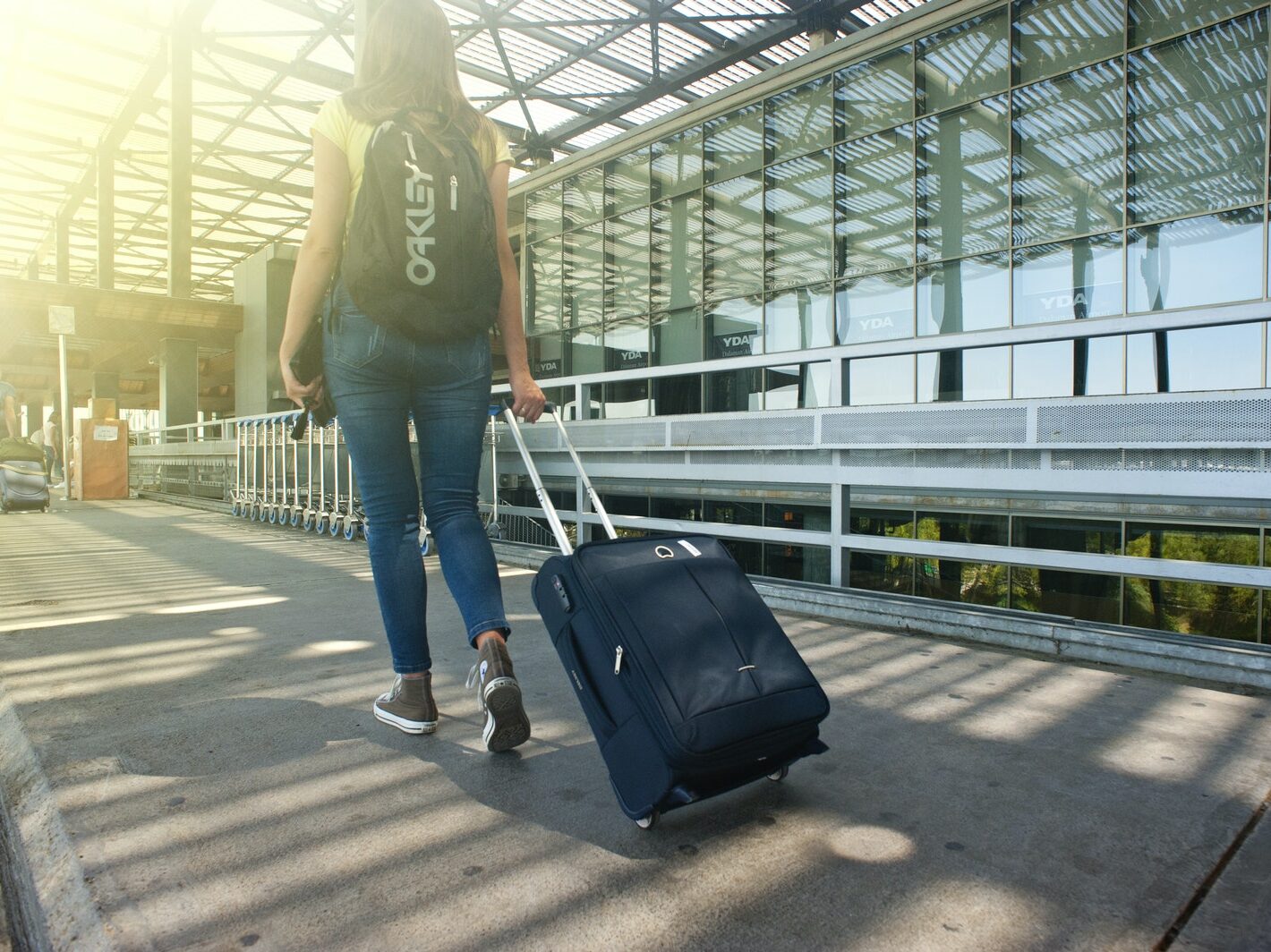 Woman Walking on Pathway While Strolling Luggage