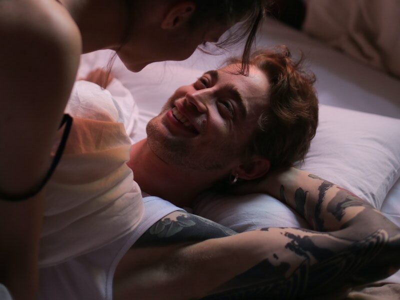 Woman in White Tank Top Lying on Bed