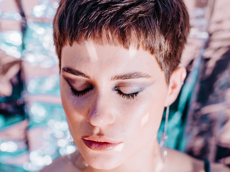 Calm woman with bright glitter on body