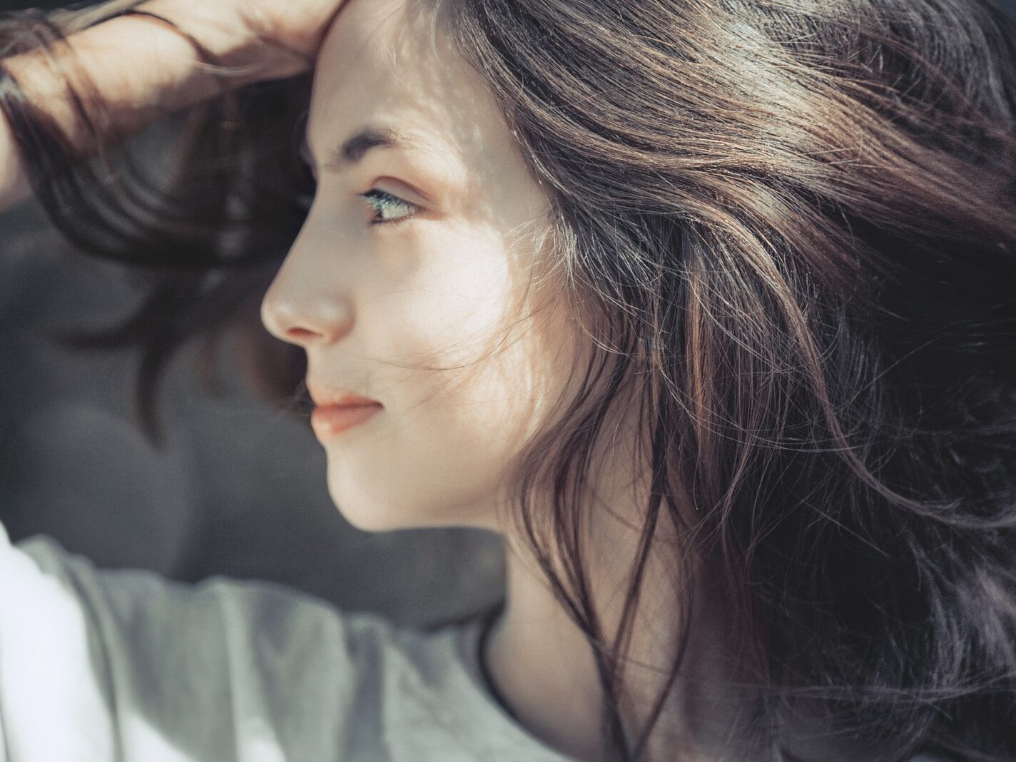 woman holding her head while facing to the side