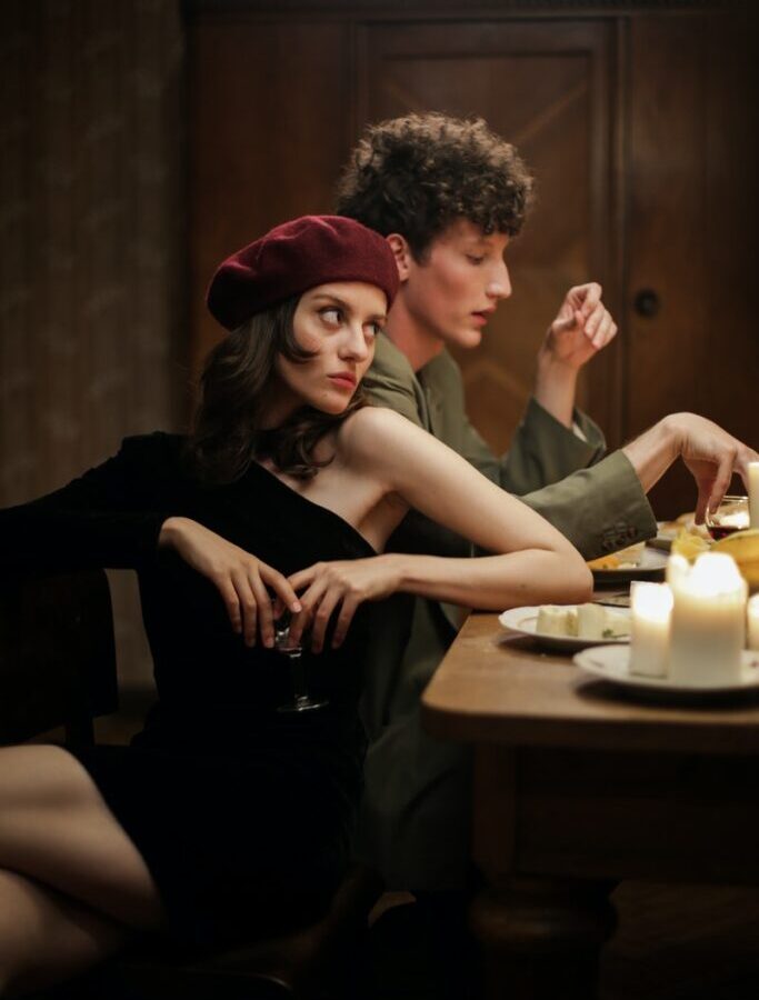 Woman in Black Sleeveless Dress Sitting Beside Woman in Black Sleeveless Dress