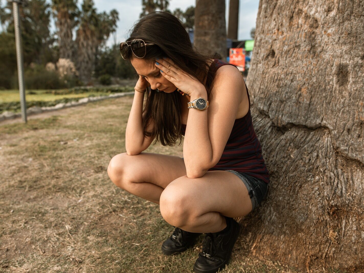 - ČasProŽeny.cz Woman in Black Tank Top and Black Shorts Sitting on Brown Rock
