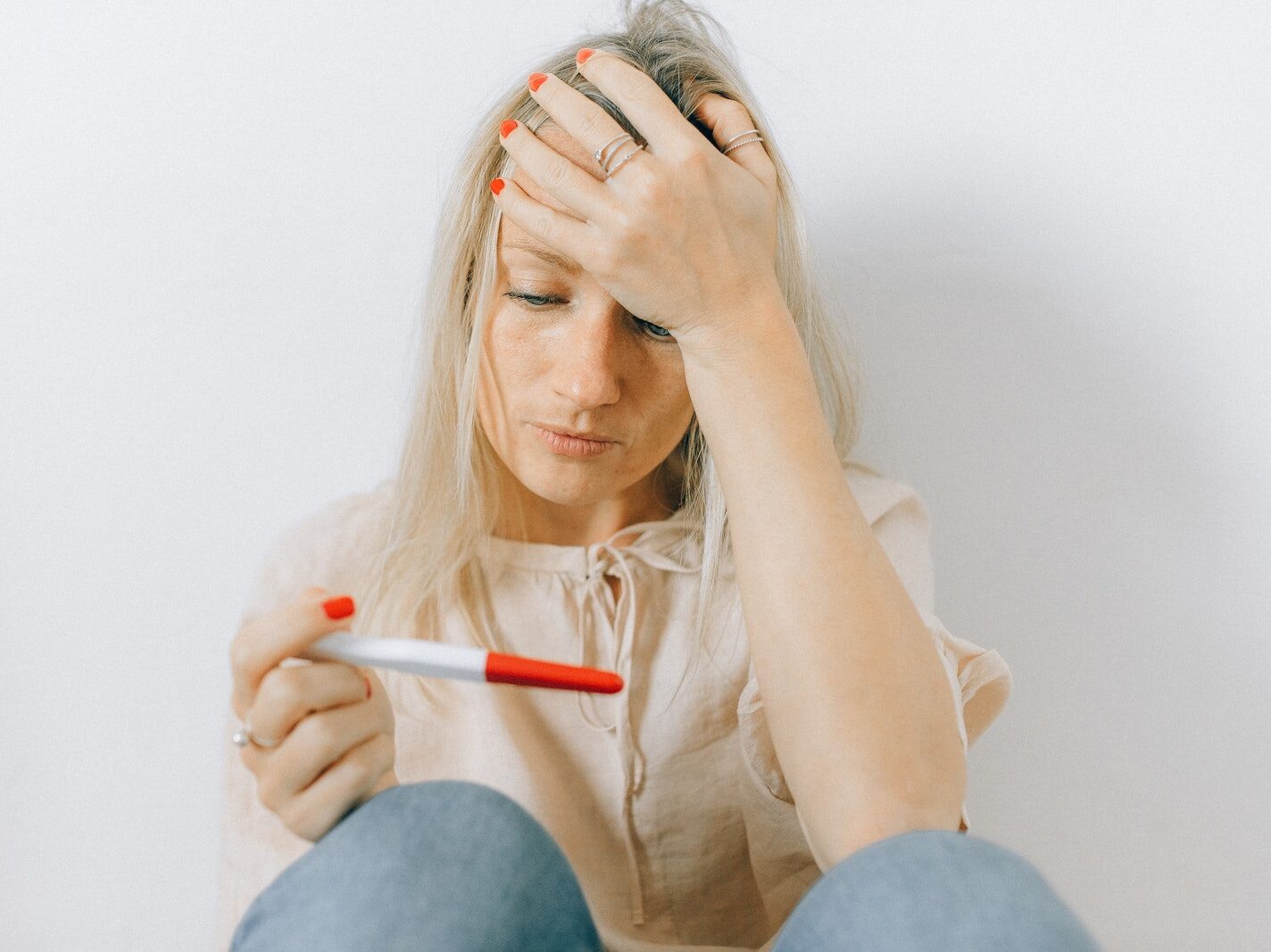 A Woman Looking Depressed at a Pregnancy Test