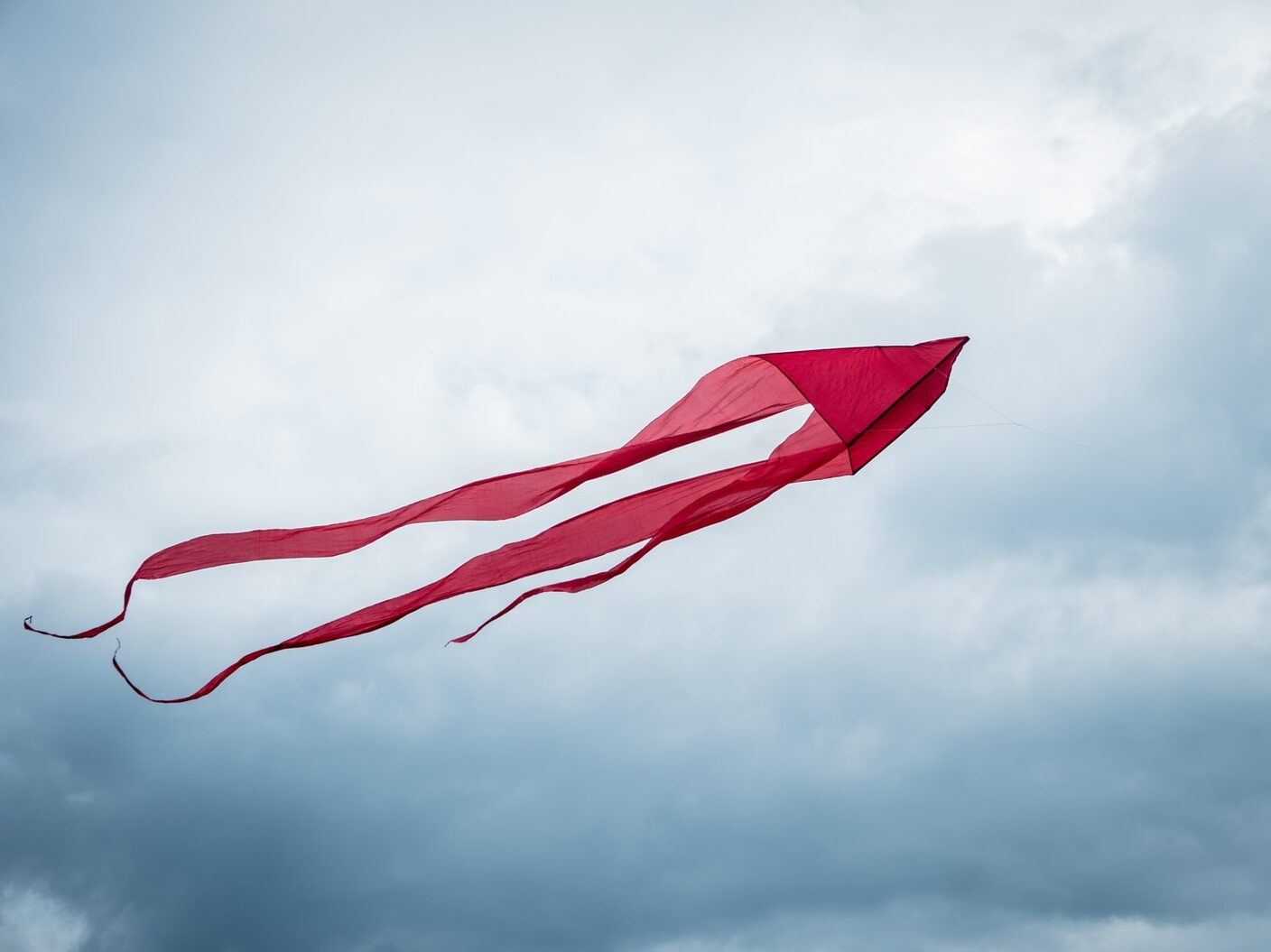 red flag on pole under cloudy sky